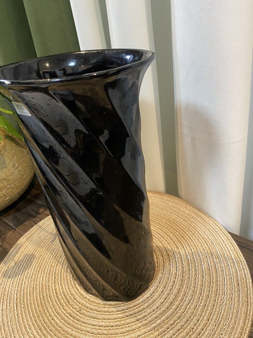 Pocket House Black Spiral Ceramic Vase (Category: Vases & Decorative Bowls) located in San Pedro. Submitted by jingay81 (Listing ID 1469370298, Image 2). Description: - Brand: Pocket House - Design: Twist spiral with a glossy black finish all around - Height: Approximately 11 inches - Condition: Original sticker label attached near the rim; includes a small chip on the top edge - Base: Stable flat bottom for secure display.