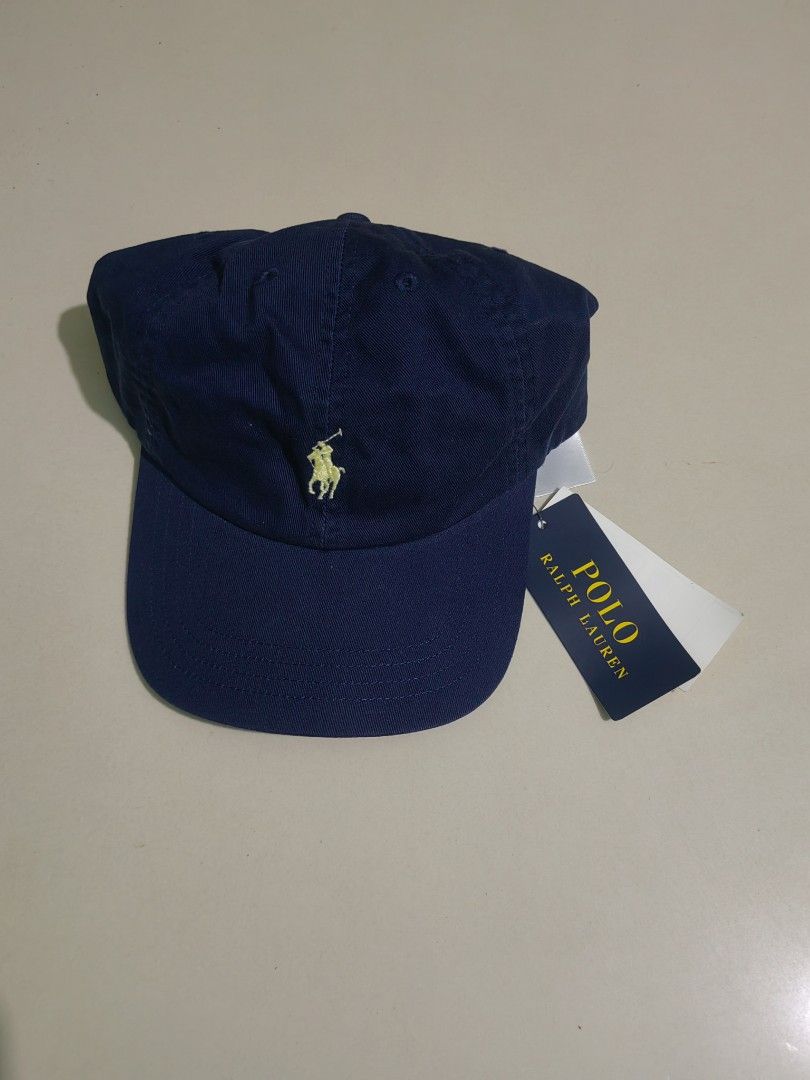 Polo Ralph Lauren Navy Blue Cap (Category: Caps & Hats) located in Las Pinas. Submitted by huslerz (Listing ID 1469260326, Image 1). Description: - Brand: Polo Ralph Lauren - Color: Classic navy blue with yellow embroidered pony logo - Material: 100% comfortable cotton for everyday wear - Size: One size fits all with adjustable back strap - Condition: Brand new with original tags still attached.