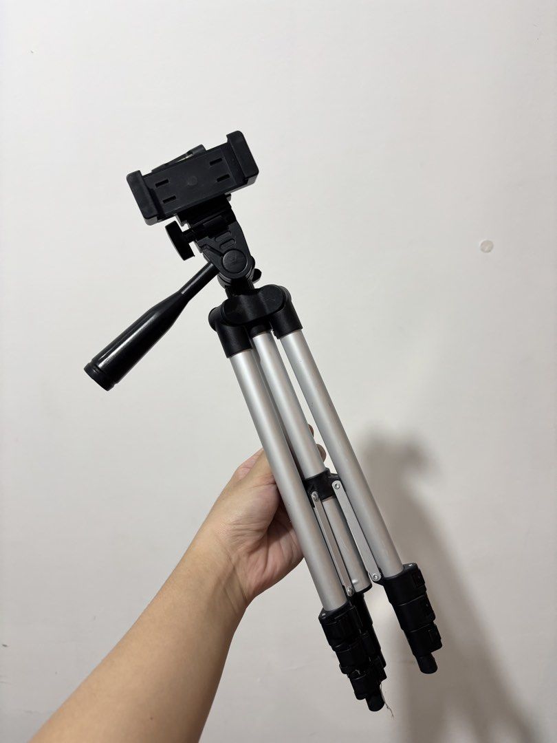 Portable Aluminum Tripod (Category: Tripods & Monopods) located in Bulacan. Submitted by janeeeeelleeeee (Listing ID 1469304328, Image 1). Description: - Material: Lightweight aluminum - Compatibility: Standard mount for cameras and smartphones - Adjustability: Extendable legs with quick-flip locks - Head: Pan head with adjustment handle and built-in bubble level - Portability: Folds down compactly for travel and daily vlogging - Condition: Clean