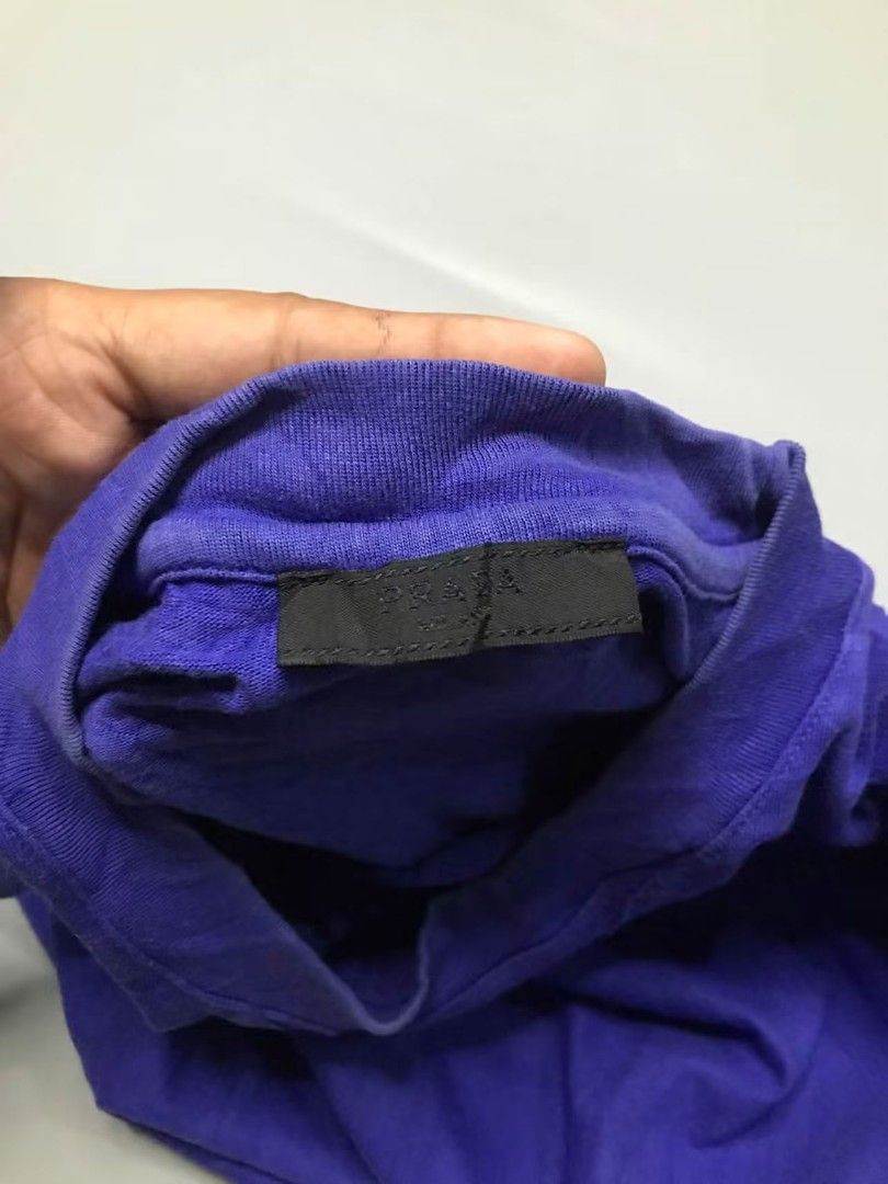 Prada Purple T-Shirt Size M (Category: Shirts) located in Calbayog City. Submitted by thrift.bucks101 (Listing ID 1469167935, Image 2). Description: Prada Crewneck Triangle Logo Shirt Good Condition Size M on tag 22x27.5 Colorate 9.1/10 issue fading on the neck line - Design: Short sleeves, crew neck, and iconic rubberized logo triangle plaque below the collar - Origin: Made in Romania - Condition: Excellent, clean inside tags.