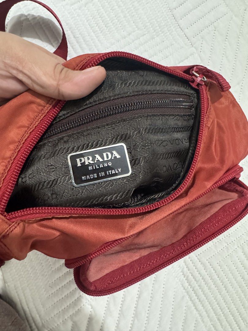 Prada Red Nylon Crossbody Flap Bag (Category: Luxury Bags & Wallets) located in Koronadal. Submitted by milagraciaukayukay123_. (Listing ID 1469296607, Image 3). Description: - Authentic red nylon Prada crossbody bag - Features iconic silver-tone triangular logo plaque and durable Lampo zipper hardware - Adjustable strap for comfortable wear - Front flap with secure buckle closure and convenient front pocket - Zippered main compartment with dark 