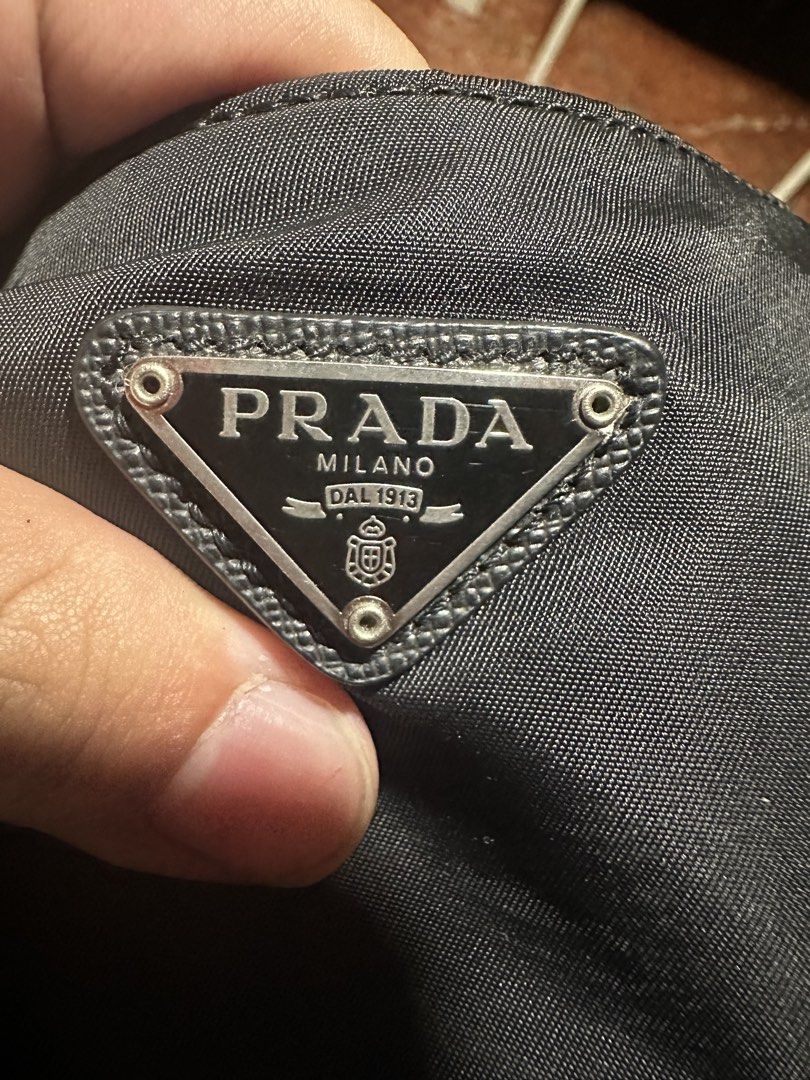Prada Re-Edition 2005 Nylon Black Shoulder Bag (Category: Luxury Bags & Wallets) located in Quezon City. Submitted by la.deals (Listing ID 1469192464, Image 3). Description: - Authentic Prada Re-Edition 2005 shoulder bag in classic black nylon - Silver-tone hardware with top zipper closure - Includes adjustable webbed strap, chain handle, and signature detachable pouch - Custom jacquard-lined interior with 'Made in Italy' tag - Highly versatile e