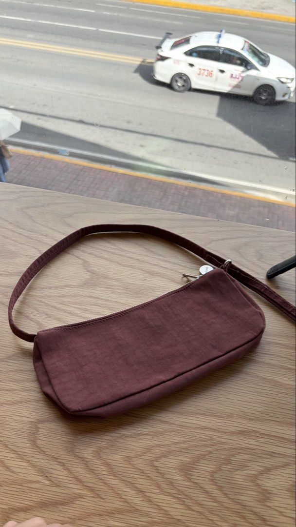 PRELOVED BAGGU NYLON POCHETTE (Category: Shoulder Bags) located in Cebu City. Submitted by kyarahmae (Listing ID 1469163785, Image 1). Description: - Color/Material: Durable maroon nylon - Closure: Top zipper with metal pull - Interior: Lined compartment with built-in card slots - Size: Compact yet spacious enough for daily essentials - Style: Simple, minimalist design ideal for casual everyday use.