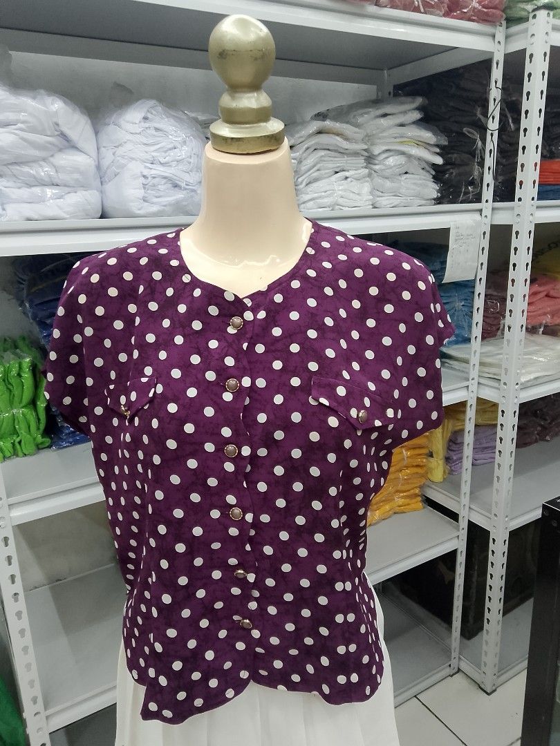 Purple polka dot button-up blouse with chest pockets (Category: Blouses) located in Midsayap. Submitted by jarethshop (Listing ID 1469324073, Image 1). Description: - Color: Purple with white polka dots - Style: Short-sleeve, button-up front with chic metallic rim buttons - Details: Scoop neckline, two front chest pockets with button flaps, and a soft, subtly textured fabric - Versatility: Great for casual days, school, or office wear - Condition
