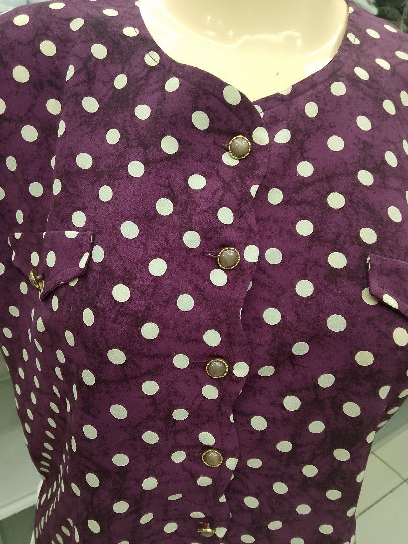 Purple polka dot button-up blouse with chest pockets (Category: Blouses) located in Midsayap. Submitted by jarethshop (Listing ID 1469324073, Image 2). Description: - Color: Purple with white polka dots - Style: Short-sleeve, button-up front with chic metallic rim buttons - Details: Scoop neckline, two front chest pockets with button flaps, and a soft, subtly textured fabric - Versatility: Great for casual days, school, or office wear - Condition