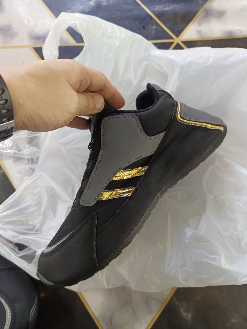 Reflectorized shoes, grey gold, size 43 (Category: Sneakers) located in Caloocan City. Submitted by vd2022 (Listing ID 1469218379, Image 2). Description: - Brand: Knar - Type: Work shoes - Color: Black and grey with gold stripes - Size: 43 - Closure: Quick-lacing dial system with twist knob - Outsole: Rugged black with circular tread pattern - Condition: Clean.