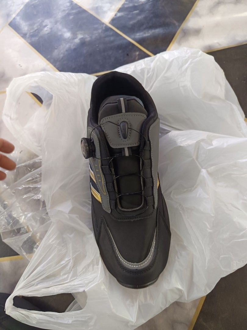 Reflectorized shoes, grey gold, size 43 (Category: Sneakers) located in Caloocan City. Submitted by vd2022 (Listing ID 1469218379, Image 3). Description: - Brand: Knar - Type: Work shoes - Color: Black and grey with gold stripes - Size: 43 - Closure: Quick-lacing dial system with twist knob - Outsole: Rugged black with circular tread pattern - Condition: Clean.