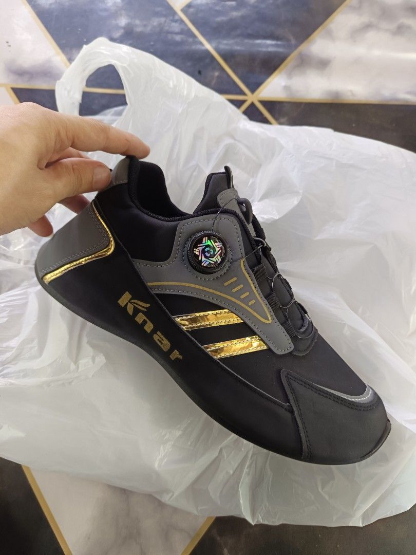 Reflectorized shoes, grey gold, size 43 (Category: Sneakers) located in Caloocan City. Submitted by vd2022 (Listing ID 1469218379, Image 1). Description: - Brand: Knar - Type: Work shoes - Color: Black and grey with gold stripes - Size: 43 - Closure: Quick-lacing dial system with twist knob - Outsole: Rugged black with circular tread pattern - Condition: Clean.