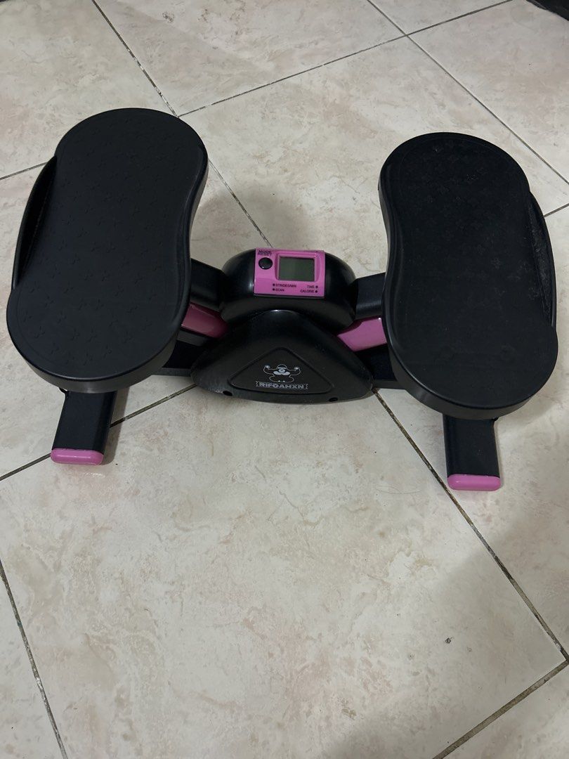 RIFOAMXN Mini Stepper Home Exercise Equipment (Category: Cardio & Fitness Machines) located in Pasig City. Submitted by prewuv (Listing ID 1469292728, Image 2). Description: Black and pink mini stepper from RIFOAMXN. Built-in electronic monitor tracking count, time, calories, and strides per minute. Operates on hydraulic cylinders. Detachable digital monitor display pops out easily for battery changes. Nonslip foot pedals ensure stability during 