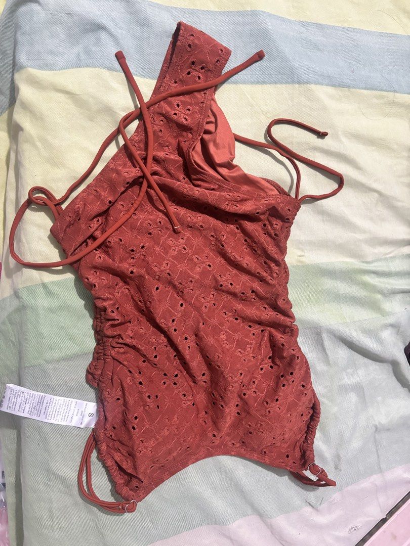 Rust Orange Eyelet Ruched One Piece Swimsuit Size S (Category: Bikinis & Swimsuits) located in Tuy. Submitted by mirpong0530 (Listing ID 1469322556, Image 3). Description: - Condition: Brand new with tags (never worn) - Color: Trendy rust orange - Design: Allover eyelet cut-out pattern with adjustable side drawstrings and ruching - Size: S RFS: Too large on me.