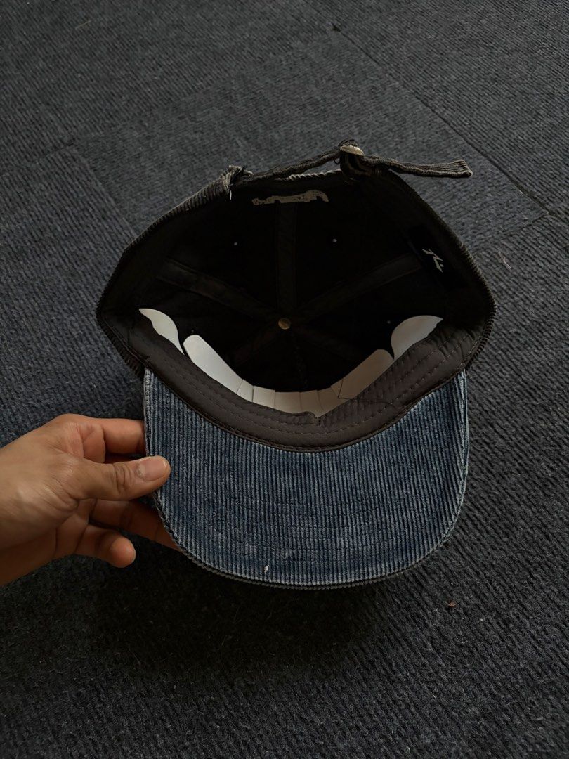 Rusty Corduroy Cap Dark Grey Blue (Category: Caps & Hats) located in Manila. Submitted by toys_hats005 (Listing ID 1469183971, Image 3). Description: - Brand: Rusty - Color: Dark grey and blue - Material: Corduroy fabric - Design: Structured panels, curved brim, and embroidered logo lettering on the front and side - Fit: Adjustable back strap with metal slide - Condition: Clean interior lining, includes original paper inserts for shape retention.