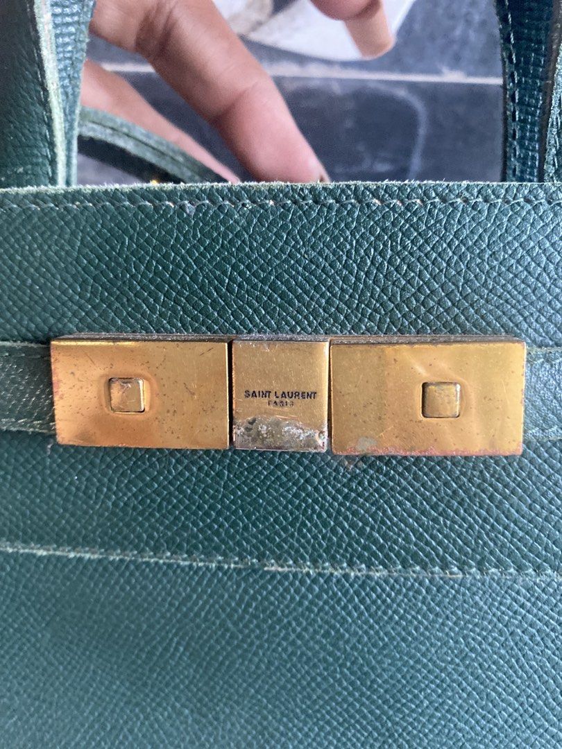 Saint Laurent Green Leather Handbag (Category: Luxury Bags & Wallets) located in Bacolod City. Submitted by chuchaystuffs (Listing ID 1469164937, Image 2). Description: - Brand: Saint Laurent - Material: Green textured leather - Hardware: Gold-tone with secure clasp closure - Features: Structured shape, dual top handles, and an adjustable/removable shoulder strap - Condition: Pre-loved with minor edge wear along the seams and light scuffs on the 