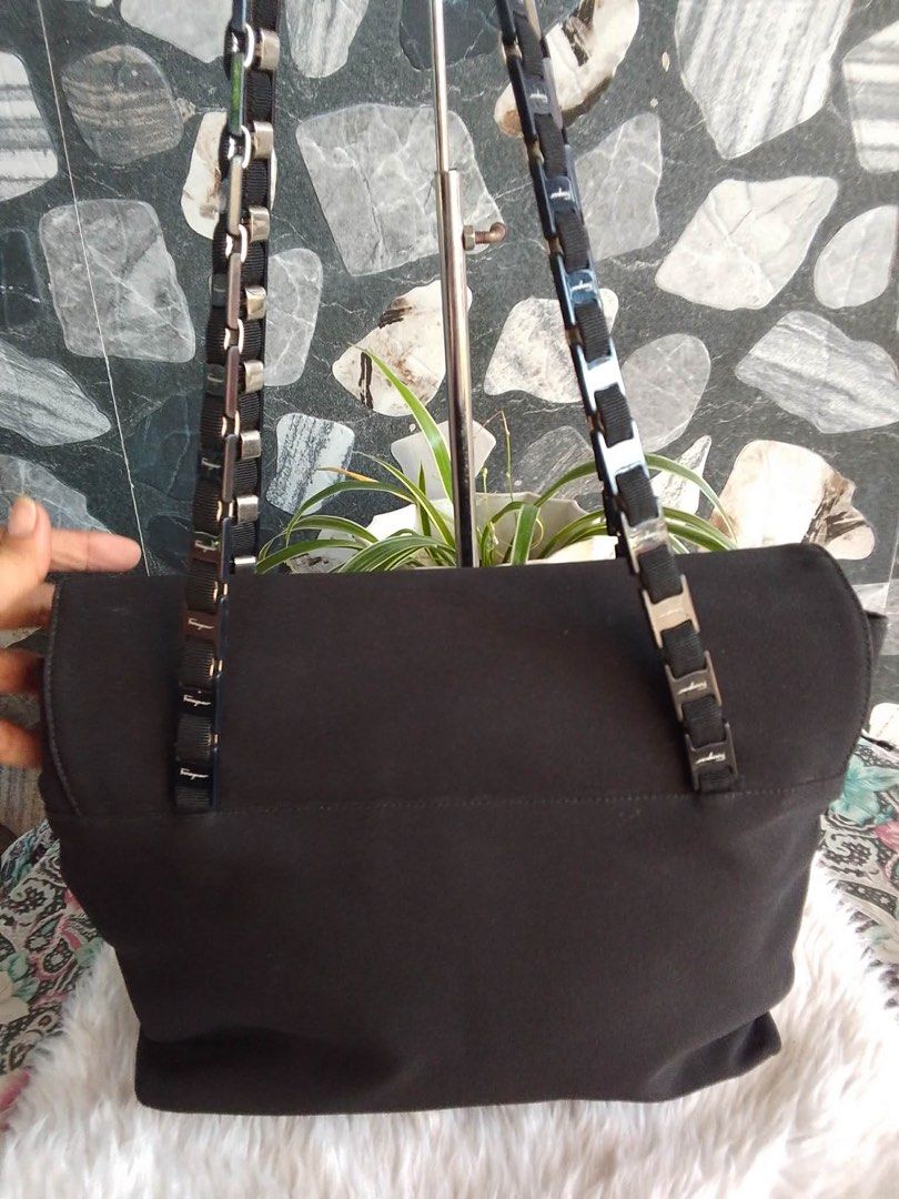 Salvatore Ferragamo Black Canvas Shoulder Bag (Category: Shoulder Bags) located in Bacolod City. Submitted by chuchaystuffs (Listing ID 1469181538, Image 2). Description: - Brand: Salvatore Ferragamo - Material: Durable black canvas with patterned fabric interior lining - Closure: Secure flap with magnetic snap button - Straps: Elegant dual chain and ribbon straps with branded metallic links - Condition: Clean sides with a sturdy, well-maintained