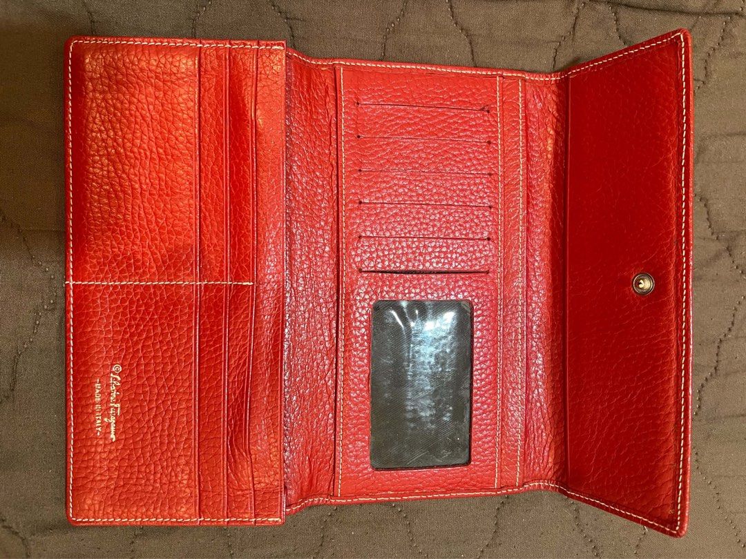 Salvatore Ferragamo Red Leather Long Wallet (Category: Wallets & Card holders) located in Quezon City. Submitted by elline_manaois02 (Listing ID 1469197696, Image 3). Description: Salvatore Ferragamo long wallet in vibrant red textured leather. Contrast white stitching along the edges. Silver-tone hardware logo plaque on the front flap. Snap button closure. Interior lined with black fabric containing multiple card slots, ID window, bill compartme