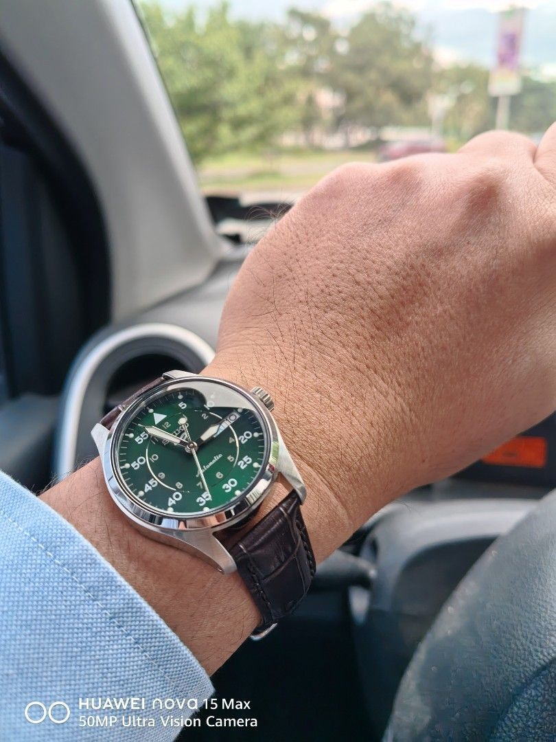 Seiko 5 Automatic Green Dial Watch (Category: Men's Watches) located in Bacoor. Submitted by happydolphin.239038 (Listing ID 1469178275, Image 2). Description: - Brand/Model: Seiko 5 Automatic Watch - Dial: Deep green with field-style outer minute track and inner 12-hour markings - Features: Silver-tone hands, day-date window at 3 o'clock, and exhibition caseback showing the automatic movement - Case: Polished stainless steel - Strap: Dark brown 