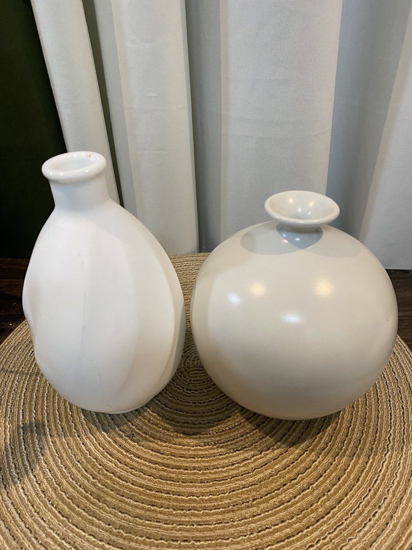 Set of 2 Ceramic White Minimalist Vases (Category: Vases & Decorative Bowls) located in San Pedro. Submitted by jingay81 (Listing ID 1469372013, Image 1). Description: - Set of 2 minimalist white ceramic vases - Neutral matte white finish that matches any interior - Tall teardrop vase with textured twist design (approx. 20.5 cm) - Round sphere vase with a flared rim (approx. 17.5 cm) - Ideal for pampas grass, fresh flowers, or as standalone decor