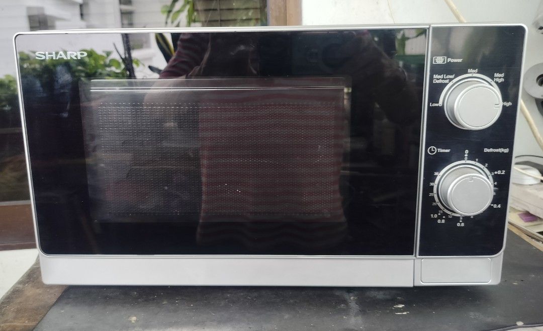Sharp Microwave Oven (Category: Ovens & Toasters) located in Singapore. Submitted by sbw8198 (Listing ID 1469186821, Image 3). Description: - Model: Sharp countertop microwave - Color: Silver and black - Dimensions: 44cm wide x 26cm tall - Features: Dual dial controls, power levels, weight defrost function, glass turntable - Condition: Clean inside and out, fully functional - Plug: Standard Singapore 3-pin plug -self collect from sembawang close 