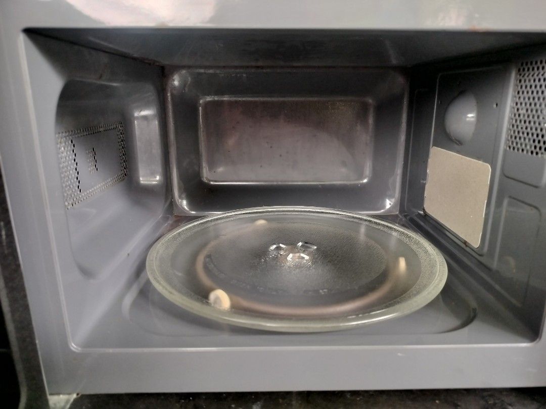 Sharp Microwave Oven (Category: Ovens & Toasters) located in Singapore. Submitted by sbw8198 (Listing ID 1469186821, Image 7). Description: - Model: Sharp countertop microwave - Color: Silver and black - Dimensions: 44cm wide x 26cm tall - Features: Dual dial controls, power levels, weight defrost function, glass turntable - Condition: Clean inside and out, fully functional - Plug: Standard Singapore 3-pin plug -self collect from sembawang close 