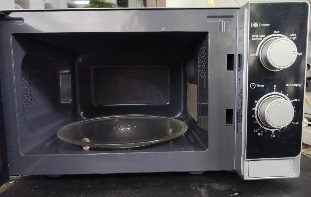 Sharp Microwave Oven (Category: Ovens & Toasters) located in Singapore. Submitted by sbw8198 (Listing ID 1469186821, Image 6). Description: - Model: Sharp countertop microwave - Color: Silver and black - Dimensions: 44cm wide x 26cm tall - Features: Dual dial controls, power levels, weight defrost function, glass turntable - Condition: Clean inside and out, fully functional - Plug: Standard Singapore 3-pin plug -self collect from sembawang close 