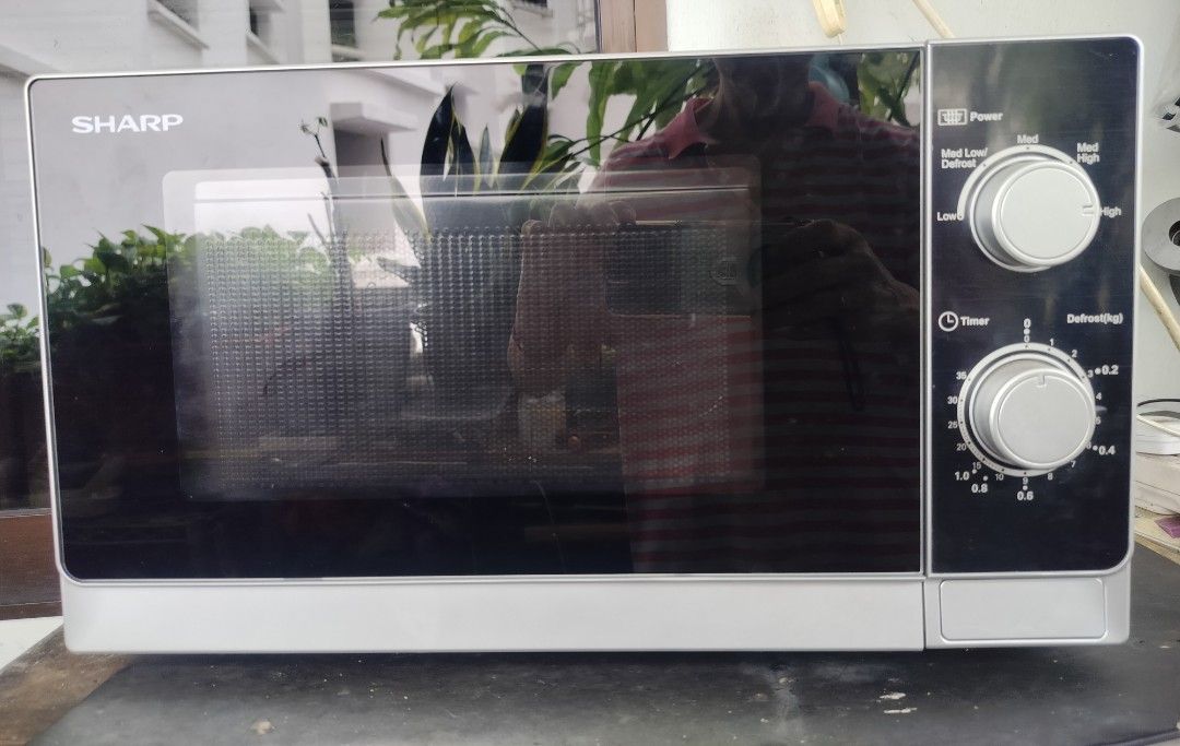 Sharp Microwave Oven (Category: Ovens & Toasters) located in Singapore. Submitted by sbw8198 (Listing ID 1469186821, Image 4). Description: - Model: Sharp countertop microwave - Color: Silver and black - Dimensions: 44cm wide x 26cm tall - Features: Dual dial controls, power levels, weight defrost function, glass turntable - Condition: Clean inside and out, fully functional - Plug: Standard Singapore 3-pin plug -self collect from sembawang close 