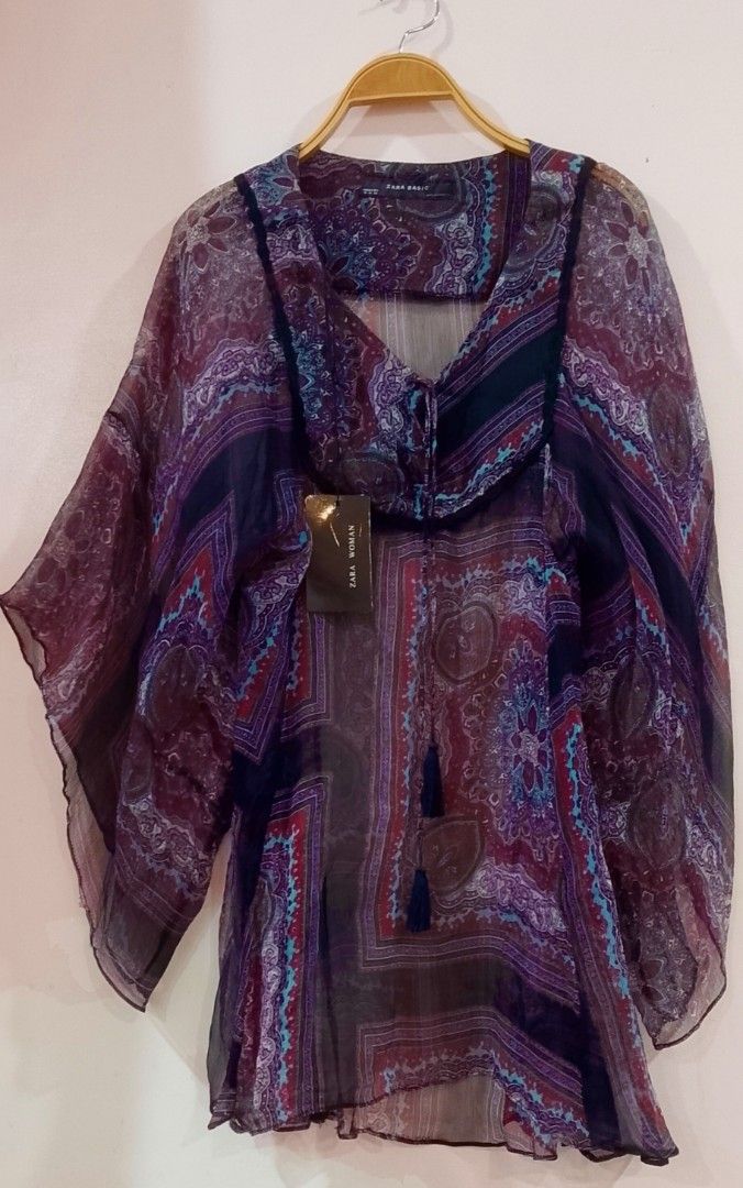 💯SILK Zara semi-sheer printed boho blouse BNWT (Category: Blouses) located in Cabanatuan. Submitted by miss.maia (Listing ID 1469304564, Image 2). Description: Zara semi-sheer printed boho blouse featuring a patchwork paisley pattern, wide butterfly sleeves, a square neck yoke with velvet trim, and front tie tassels 💯 SILK BNWT.