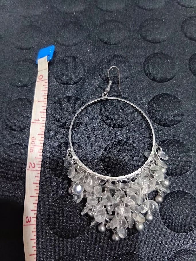 Silver Beaded Hoop Dangle Earrings (Category: Earrings) located in Caloocan City. Submitted by mma_222 (Listing ID 1469197762, Image 3). Description: - Style: Large silver hoop earrings with hanging beaded fringe - Design: Triangle dangle shape featuring clear faceted beads and small silver spheres - Closure: Silver-toned fishhook closures - Comfort: Lightweight design for all-day wear - Versatility: Great statement piece for evening outings or c