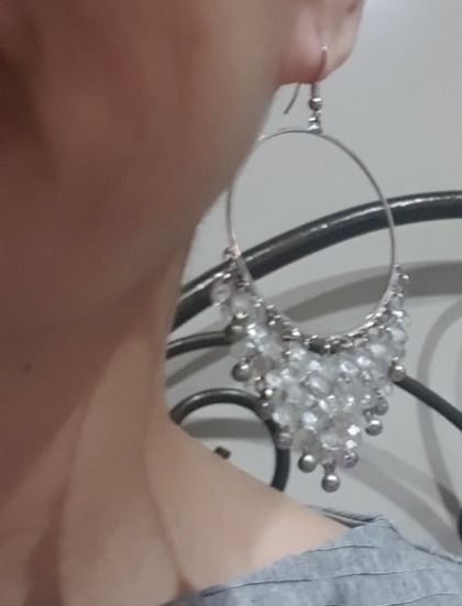 Silver Beaded Hoop Dangle Earrings (Category: Earrings) located in Caloocan City. Submitted by mma_222 (Listing ID 1469197762, Image 2). Description: - Style: Large silver hoop earrings with hanging beaded fringe - Design: Triangle dangle shape featuring clear faceted beads and small silver spheres - Closure: Silver-toned fishhook closures - Comfort: Lightweight design for all-day wear - Versatility: Great statement piece for evening outings or c