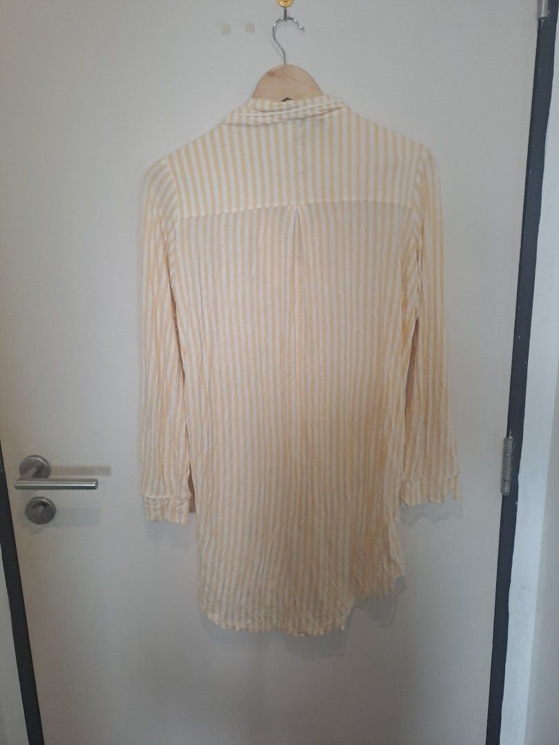 Sleepwear rayon yellow stripes (Category: Dresses) located in Manila. Submitted by joanbalde39643 (Listing ID 1469230406, Image 2). Description: The item in the image is a women's yellow and white vertical striped nightshirt featuring a button-down front, long sleeves, a notch collar, and a single chest patch pocket. It is designed as an oversized, relaxed lounge dress or a sleepwear top..
