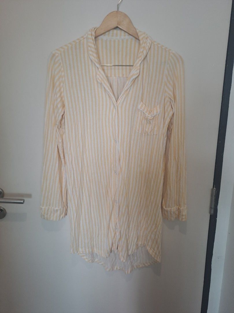 Sleepwear rayon yellow stripes (Category: Dresses) located in Manila. Submitted by joanbalde39643 (Listing ID 1469230406, Image 1). Description: The item in the image is a women's yellow and white vertical striped nightshirt featuring a button-down front, long sleeves, a notch collar, and a single chest patch pocket. It is designed as an oversized, relaxed lounge dress or a sleepwear top..