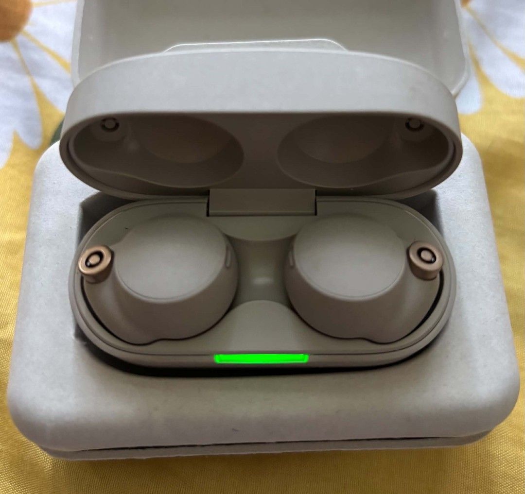 Sony WF-1000XM4 Wireless Earbuds (Category: Headphones & Headsets) located in Bayombong. Submitted by rnstrifty (Listing ID 1469177214, Image 1). Description: Sony WF-1000XM4 wireless noise canceling earbuds in silver/beige colorway. Includes charging case and original paper pulp packaging box. Earbuds sit securely inside the molded case. Battery status indicator lights up green on the front. Fully functional charging case and earphones..