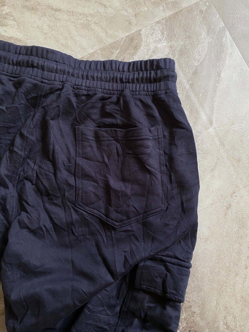 Stone Island Navy Blue Cargo Sweatpants (Category: Joggers) located in Butuan. Submitted by jc13thrifts (Listing ID 1469342565, Image 3). Description: - Brand: Stone Island - Color: Navy Blue - Material: Comfortable, high-quality cotton - Waist: Elastic waistband with adjustable drawstring - Pockets: Functional side cargo pockets and a back pocket - Signature Detail: Iconic yellow compass badge on the left leg - Cuffs: Ribbed ankles for a snug fi