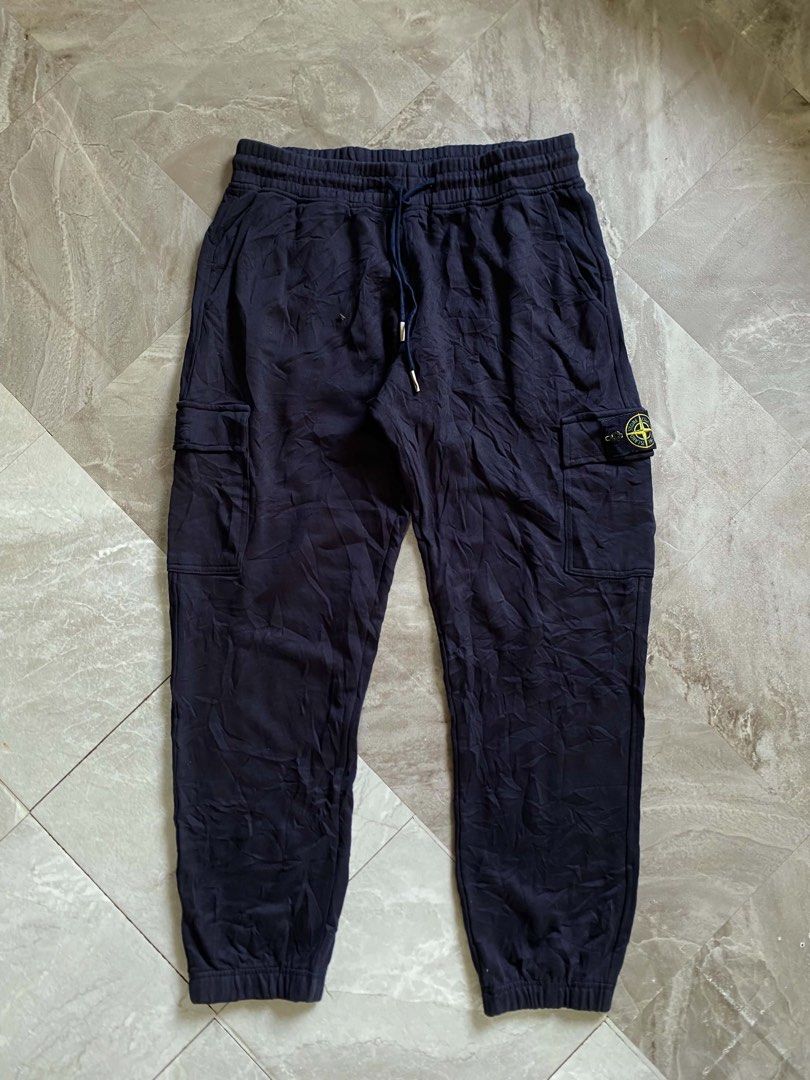 Stone Island Navy Blue Cargo Sweatpants (Category: Joggers) located in Butuan. Submitted by jc13thrifts (Listing ID 1469342565, Image 1). Description: - Brand: Stone Island - Color: Navy Blue - Material: Comfortable, high-quality cotton - Waist: Elastic waistband with adjustable drawstring - Pockets: Functional side cargo pockets and a back pocket - Signature Detail: Iconic yellow compass badge on the left leg - Cuffs: Ribbed ankles for a snug fi
