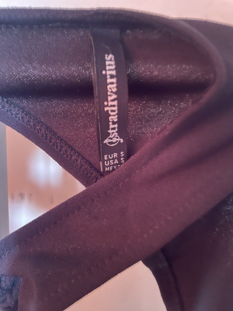 Stradivarius Black Bodysuit Size S (Category: Sleeveless) located in Manila. Submitted by zzjjm (Listing ID 1469216098, Image 2). Description: - Brand: Stradivarius - Size: S (fits EUR/USA S) - Color: Classic Black - Design: Unique front cutout with central ring and cross straps - Style: Sleeveless, stretchable fabric - Condition: Great versatile basic for layering or wearing on its own.