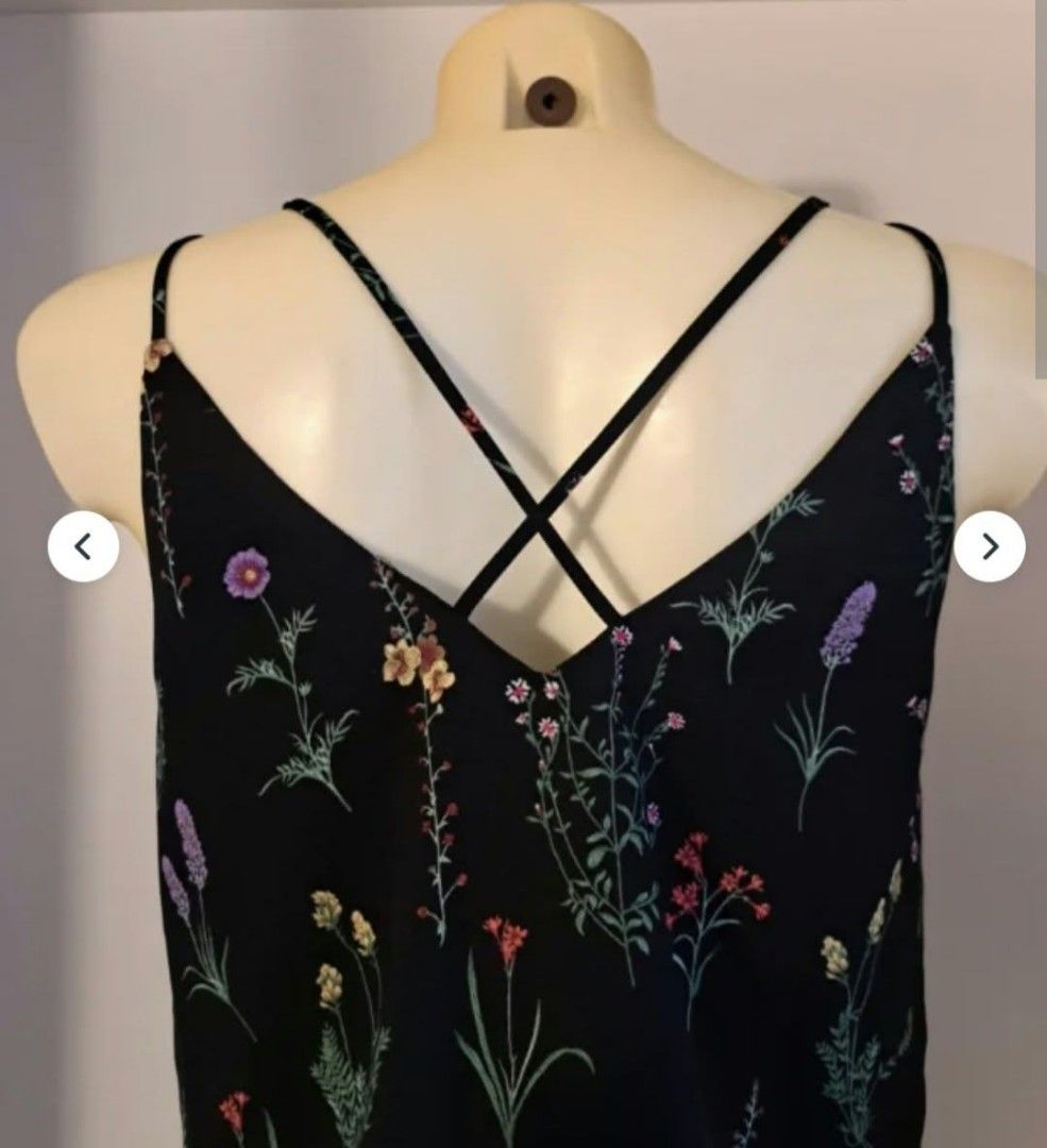 Stradivarius Black Floral Cami Top (Category: Sleeveless) located in Paranaque City. Submitted by calm_youngstore7 (Listing ID 1469287310, Image 3). Description: - Brand: Stradivarius - Size: M - Design: Black with all-over colorful wildflower print - Straps: Double spaghetti straps with a cute criss-cross back detail - Fabric: Lightweight, ideal for warm weather or layering - Environment: Clean, smoke-free home.