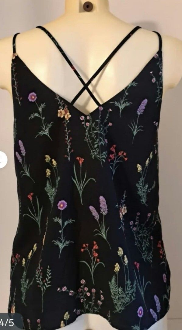Stradivarius Black Floral Cami Top (Category: Sleeveless) located in Paranaque City. Submitted by calm_youngstore7 (Listing ID 1469287310, Image 2). Description: - Brand: Stradivarius - Size: M - Design: Black with all-over colorful wildflower print - Straps: Double spaghetti straps with a cute criss-cross back detail - Fabric: Lightweight, ideal for warm weather or layering - Environment: Clean, smoke-free home.