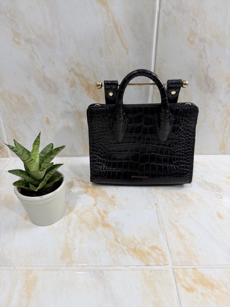 Strathberry Black Croc Embossed Mini Tote Bag (Category: Tote Bags) located in Manila. Submitted by haveago0dthrift (Listing ID 1469257290, Image 1). Description: - Brand: Strathberry - Color: Classic Black - Material: Crocodile-embossed leather with gold-tone hardware - Features: Signature top bar, protective metal feet, structured self-standing design, and clean exterior leather - Condition: Noticeable wear and peeling on the leather handles (p