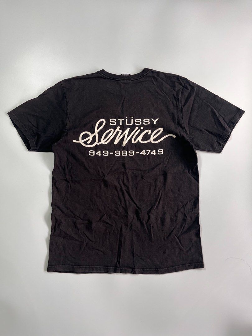 Stussy Service Black Graphic Tee Size M (Category: Tshirts & Polo Shirts ) located in Iloilo. Submitted by lowesdrift (Listing ID 1469204461, Image 2). Description: - Brand: Stussy - Item: Service T-Shirt - Color: Washed Black with natural vintage fade - Size: Medium (Tag size) - Material: 100% Cotton, Made in Honduras - Design: Small front left chest logo, large 'Stussy Service 949-989-4749' back graphic - Style: Classic crew neck, short sleeve 