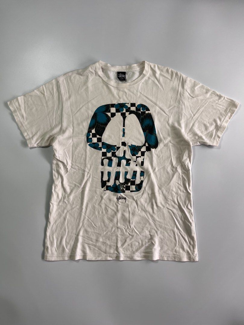 Stussy Skull Graphic Tee White Large (Category: Tshirts & Polo Shirts ) located in Iloilo. Submitted by lowesdrift (Listing ID 1469207141, Image 1). Description: - Brand: Stussy - Size: Large - Design: Large checkerboard skull print with blue floral details and signature branding - Neckline: Classic crew neck with original black brand tag - Condition: Soft and comfortably broken-in from normal wear - Style: Streetwear / Casual.