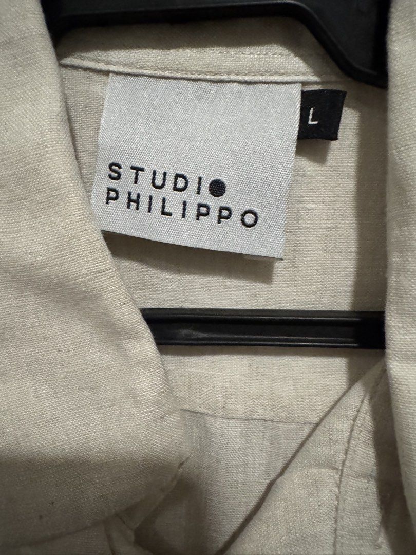 SUPPORT LOCAL: Studio Philippo Barong short sleeves Size L (Category: Formal Shirts) located in Taguig. Submitted by dependingonvibe (Listing ID 1469276271, Image 2). Description: - Brand: Studio Philippo - Size: L (tag on collar) - Material: Lightweight linen fabric - Color: Off-white with cute black embroidered figures on the front - Style: Camp collar, relaxed fit, plain back with shoulder yoke details - Condition: Great casual shirt for warm 