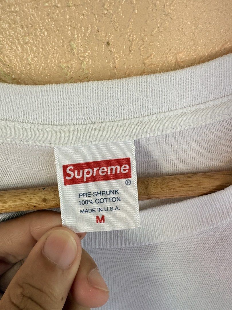 Supreme x Thrasher Skyline White T-Shirt Medium (Category: Tshirts & Polo Shirts ) located in Pozorrubio. Submitted by zionegotthrift (Listing ID 1469200485, Image 3). Description: - Brand: Supreme x Thrasher - Color: White - Size: Medium (M) - Design: Blue Thrasher text graphic over black NY skyline silhouette with Supreme red box logo neck tag - Material: 100% pre-shrunk cotton - Origin: Made in USA - Condition: 100% authentic and well-maintain