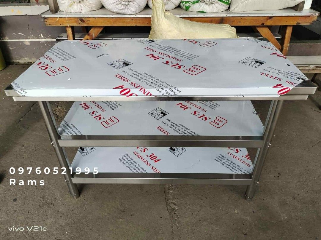 SUS 304 Stainless Steel Kitchen Work Table with Shelves (Category: Tables & Sets) located in Manila. Submitted by acykt18 (Listing ID 1469168825, Image 3). Description: - Material: Premium SUS 304 stainless steel - Storage: Multiple undershelves for extra space - Build: Heavy-duty construction with sturdy metal legs - Condition: Brand new with protective plastic film still intact - Ideal For: Restaurant kitchens, food prep, and home use - Assembl