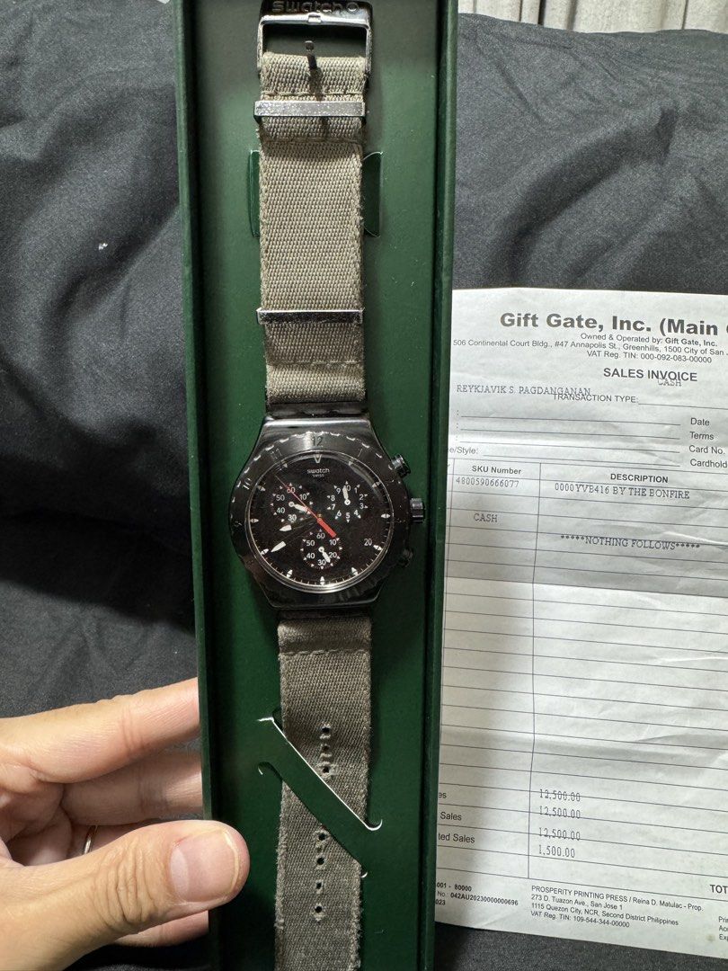 Swatch Irony Chrono By The Bonfire (Category: Men's Watches) located in Cavite. Submitted by mrswitchfoot (Listing ID 1469392729, Image 2). Description: - Model: Swatch Irony Chrono By The Bonfire (YVB416) - Dial: Black with textured 3D details and striking red and white print - Case: Brushed stainless steel with a sleek black PVD coating - Strap: Durable green textile strap with metal loops - Inclusions: Complete with original green box and offi