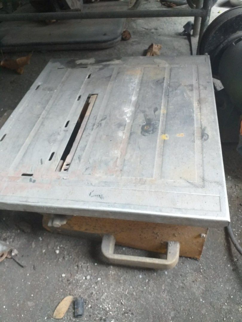 Table Top Tile Saw Wet Cutting Machine (Category: Construction Tools & Equipment) located in Quezon City. Submitted by madelrivera (Listing ID 1469272971, Image 2). Description: - Heavy-duty tile saw built for cutting ceramic and stone tiles - Sturdy yellow base with a durable metal tabletop - Integrated ruler scale along the left edge for precise measuring - Standard center blade slot and attached power cord - Shows minor dirt and rust spots fro