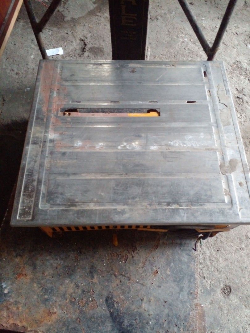 Table Top Tile Saw Wet Cutting Machine (Category: Construction Tools & Equipment) located in Quezon City. Submitted by madelrivera (Listing ID 1469272971, Image 1). Description: - Heavy-duty tile saw built for cutting ceramic and stone tiles - Sturdy yellow base with a durable metal tabletop - Integrated ruler scale along the left edge for precise measuring - Standard center blade slot and attached power cord - Shows minor dirt and rust spots fro