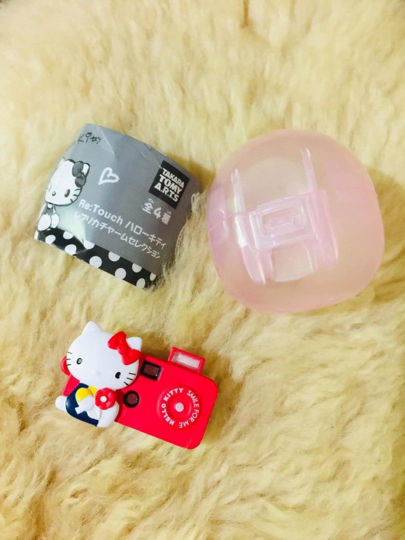 Takara Tomy Arts Hello Kitty Re:Touch Charm (Category: Character Goods) located in Baguio. Submitted by izza_thrifty (Listing ID 1469167909, Image 1). Description: - Authentic Takara Tomy Arts Kitty Re:Touch charm gachapon - Red toy camera design featuring Kitty holding a flower - Comes complete with original capsule and paper insert - Great collectible piece for Sanrio fans - Perfect cute accessory for your bag or keys.
