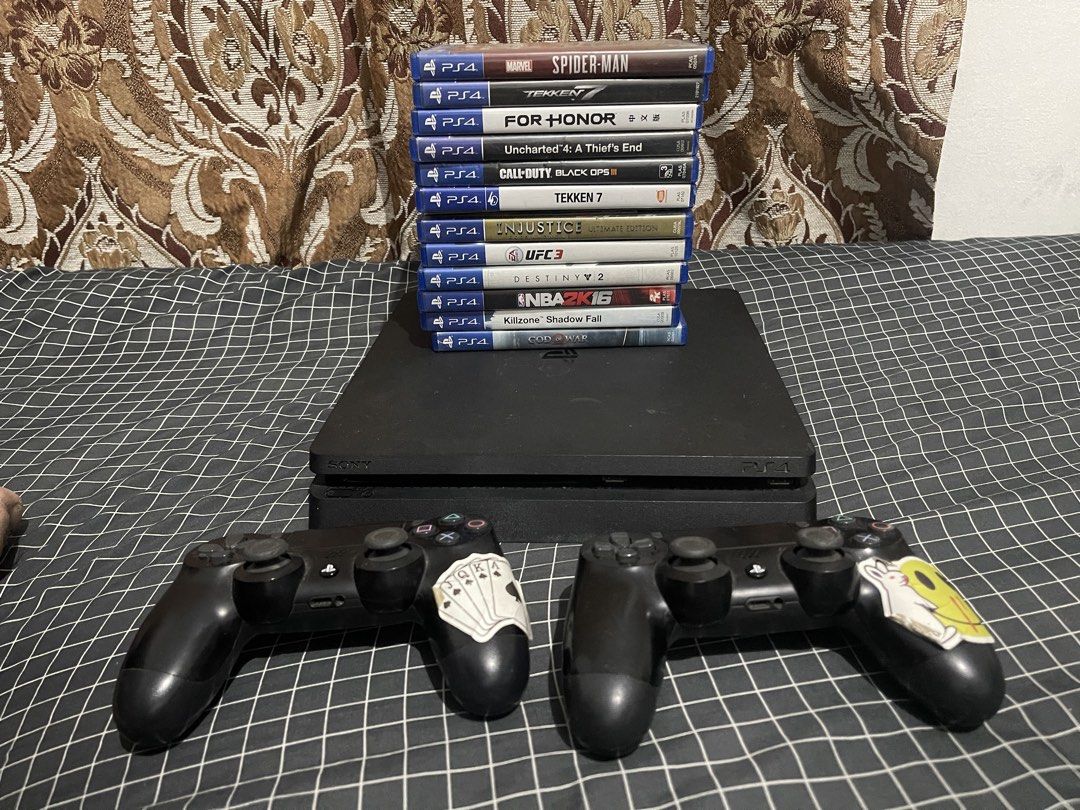 (Take all) ps4 500gb 12 games 2 controller (Category: PlayStation) located in Rizal. Submitted by percydwom (Listing ID 1469253309, Image 1). Description: - Item: Black PlayStation 4 Console Bundle - Controllers: 2x DualShock 4 controllers (both feature stickers on the right grip area) - Games Included (12 Physical Discs): Marvel's Spider-Man, Tekken 7 (2 copies), For Honor, Uncharted 4: A Thief's End, Call of Duty: Black Ops III, Injustice: Ulti