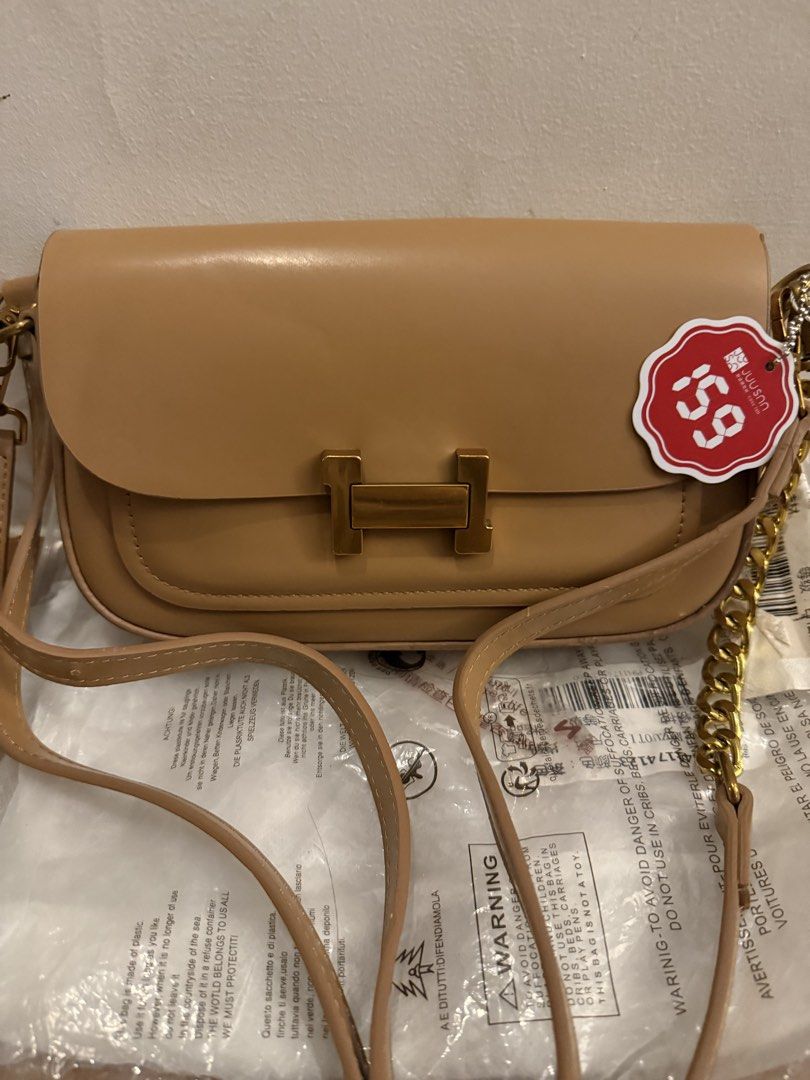 Tan shoulder bag with gold hardware (Category: Shoulder Bags) located in Bulacan. Submitted by emjay_17 (Listing ID 1469176818, Image 2). Description: - Brand new with tags, still in original plastic packaging - Chic tan color with elegant gold-tone hardware - Structured flap closure for a clean, minimalist look - Includes an adjustable main strap plus a stylish extra chain detail - Roomy enough to easily fit your daily essentials.