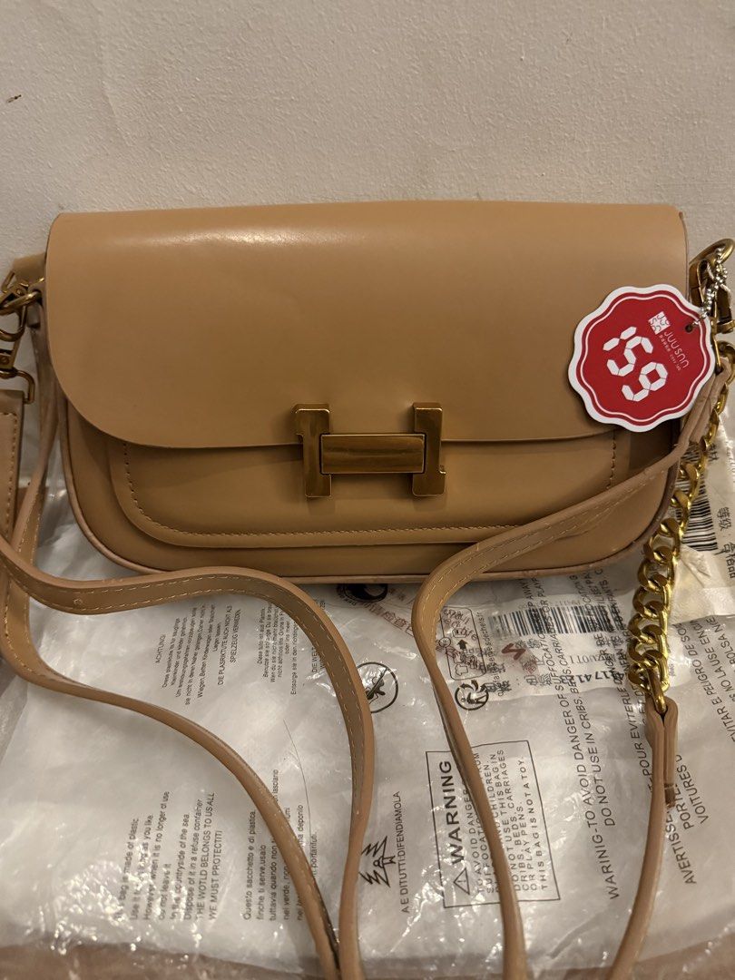 Tan shoulder bag with gold hardware (Category: Shoulder Bags) located in Bulacan. Submitted by emjay_17 (Listing ID 1469176818, Image 3). Description: - Brand new with tags, still in original plastic packaging - Chic tan color with elegant gold-tone hardware - Structured flap closure for a clean, minimalist look - Includes an adjustable main strap plus a stylish extra chain detail - Roomy enough to easily fit your daily essentials.