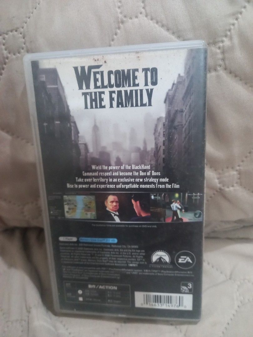 The Godfather PSP Game (Category: PlayStation) located in Valenzuela. Submitted by retro.rush (Listing ID 1469313446, Image 2). Description: - Game: The Godfather - Platform: Psp - Packaging: Standard keep case with minor dust and wear on the plastic sleeve - Features: Includes gameplay screenshots and "Welcome to the Family" text on the back cover - Publishers/Licensors: EA and Paramount logos present - Condition: Good, playable condition (ideal