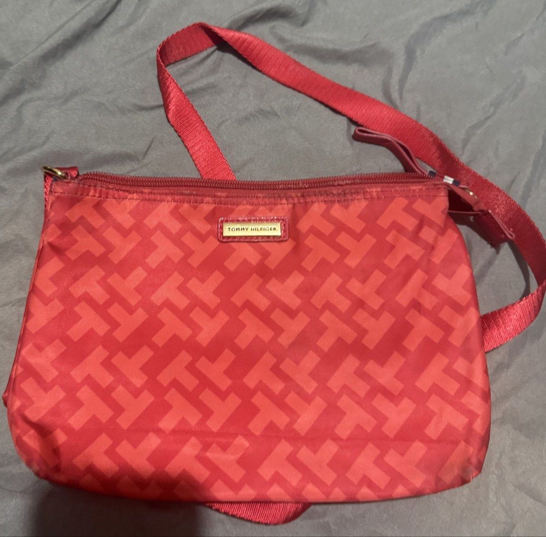 Tommy Hilfiger Red Monogram Crossbody Bag (Category: Cross-body Bags) located in Cainta. Submitted by mykee1 (Listing ID 1469228719, Image 3). Description: - Brand: Tommy Hilfiger - Style: Crossbody bag - Color: Red with all-over T monogram pattern - Material: Durable nylon - Hardware: Gold-tone logo plaque on the front - Closure: Secure zip-top - Strap: Adjustable fabric shoulder strap - Accent: Small side tab featuring the signature red, white,